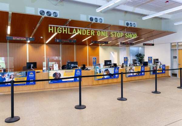 A Highlander One Stop Shop sign hangs above desks