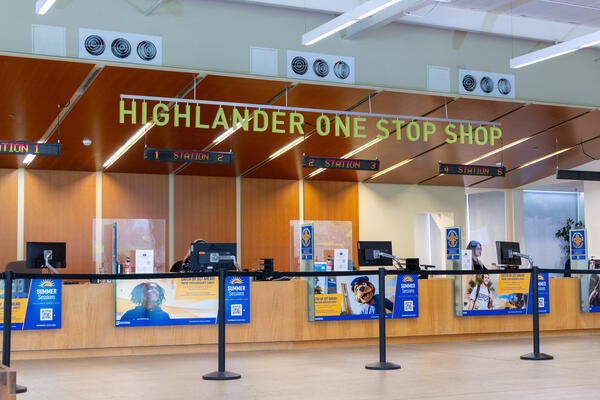 The HOSS help desks with sign overhead that reads Highlander One-Stop Shop.