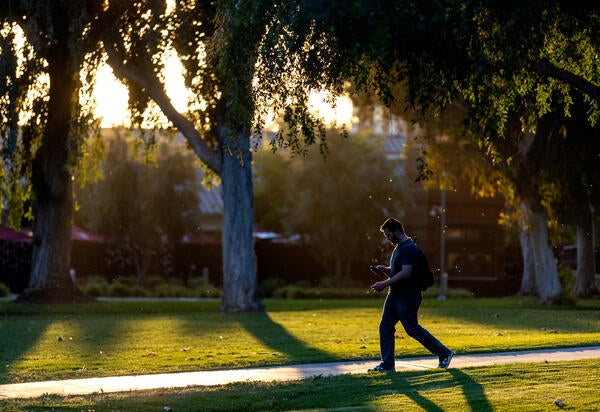 A student walks across the UCR campus