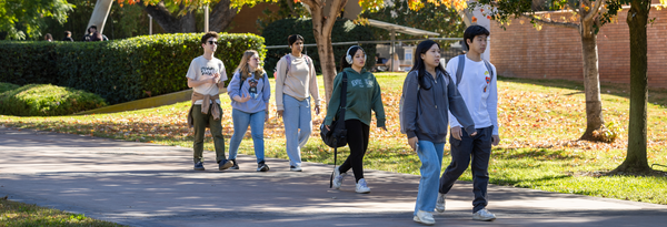 A group of students walks through the UCR campus
