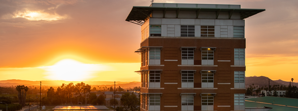 A UCR building in front of a sunset