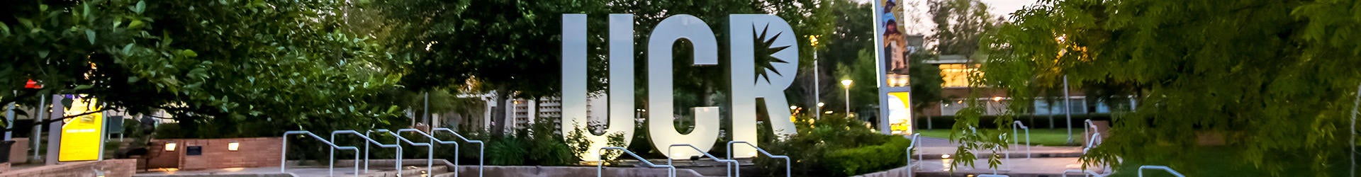 Panoramic view of large iconic metallic UCR logo sculpture that is surrounded by green grass.
